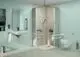 Badezimmer mit blauer Wandfarbe, Dusche mit Haltegriffen, Waschbecken und Toilette. Ideal Standard Produkte sind integriert in die barrierefreie Gestaltung.